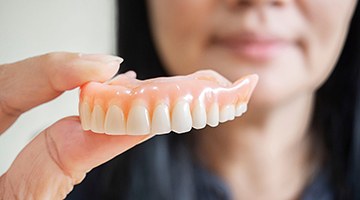 Woman holding her denture