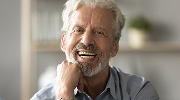 An older man smiling and looking at the camera