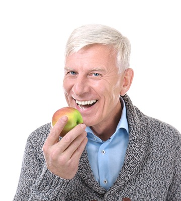 senior man with strong teeth eating an apple