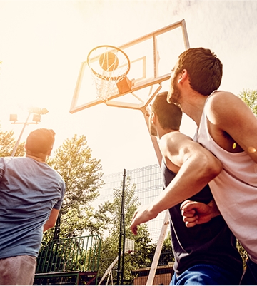 Three men playing basketball together