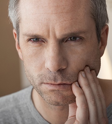 Man in pain holding jaw