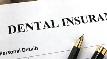 Dental insurance paperwork with pens for cost of emergency dental care in Colleyville