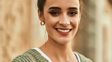 Healthy young woman smiles after visiting her Colleyville emergency dentist