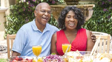 Older couple with dental implants in Colleyville enjoying a meal