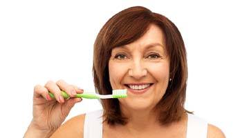Woman brushing teeth in Colleyville