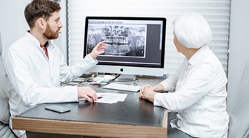 dental implant dentist in Colleyville showing a patient their X-rays 