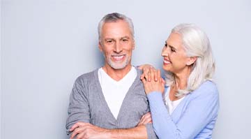 Older couple with dental implants in Colleyville smiling