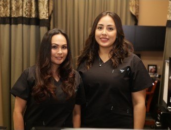 patients smiling at receptionist desk in Colleyville