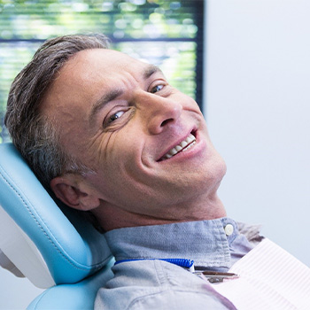 Man sitting in dentist’s chair smiling after nitrous oxide