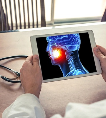 dentist looking at an illustration of a mouth on a tablet