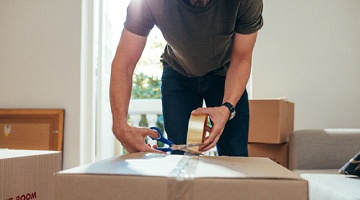 Man cutting tape using a pair of scissors