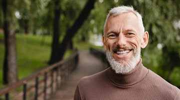 Man in sweater smiling after teeth whitening in Colleyville, TX