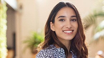 Woman in flowered shirt smiling after teeth whitening in Colleyville, TX