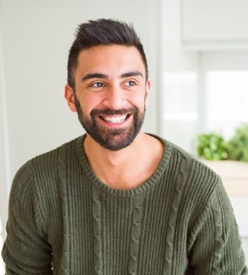 person sitting in a kitchen and smiling