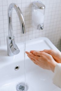 Woman washing her hands to prevent COVID-19.