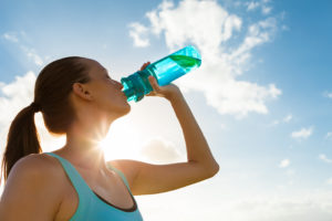 Woman drinking water after going on a run