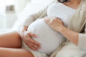 Pregnant woman holding her belly.