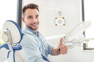 Man at dentist smiling and giving thumbs up